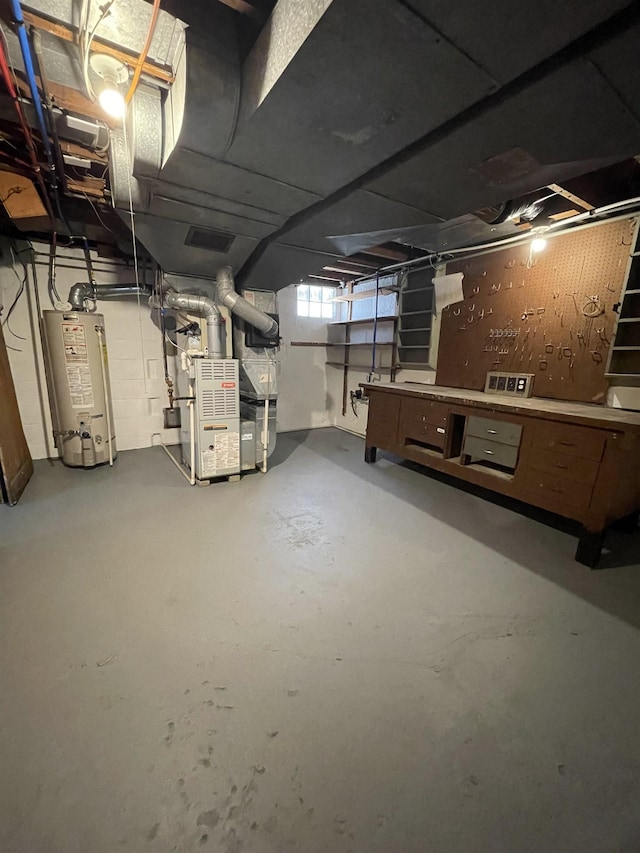 basement featuring visible vents, heating unit, and water heater