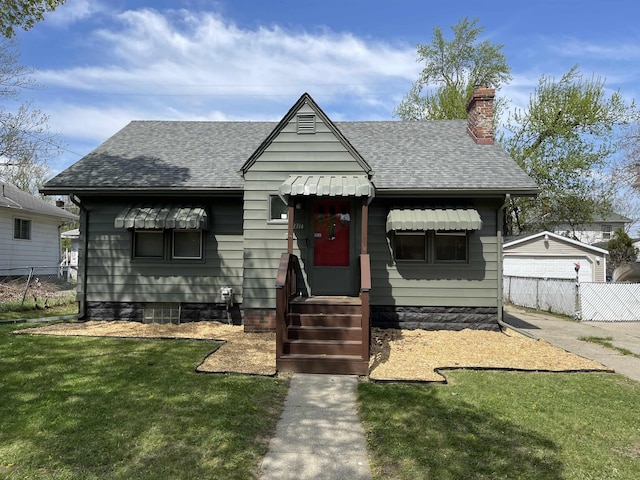 bungalow-style house with roof with shingles, fence, and a chimney