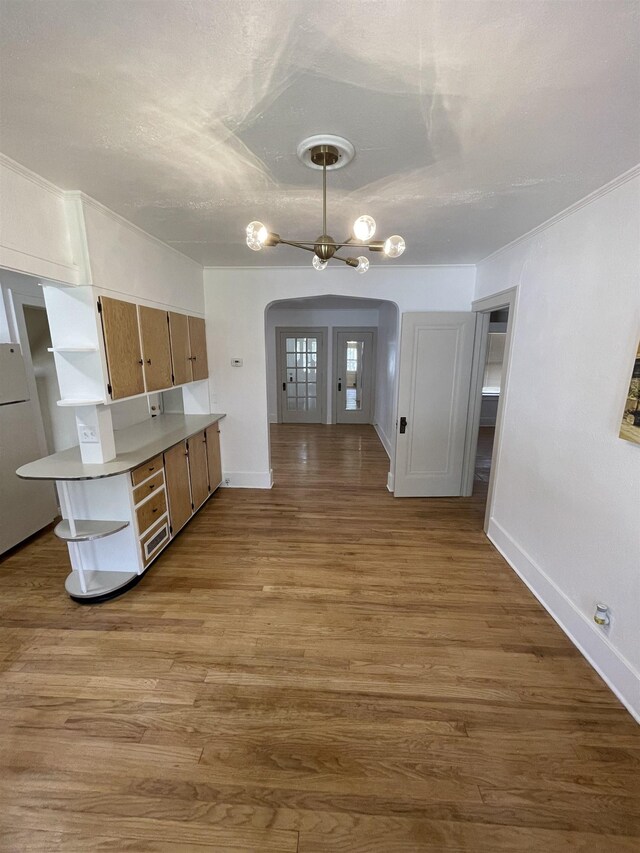2314 Begole St, Flint, MI 48504 - kitchen with arched walkways, baseboards, and wood finished floors