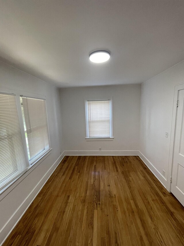 unfurnished room featuring baseboards and wood finished floors