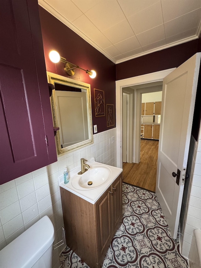 2314 Begole St, Flint, MI 48504 - bathroom with tile walls, vanity, toilet, ornamental molding, and wainscoting