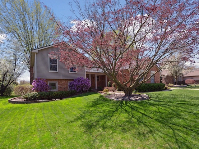 view of front facade featuring brick siding and a front lawn