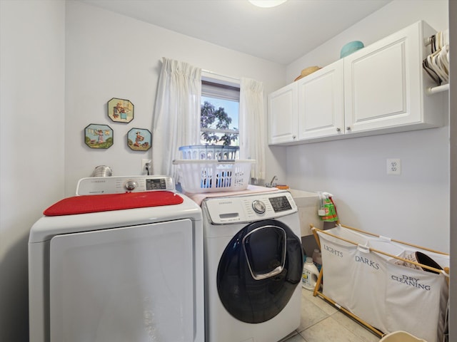laundry room with cabinet space, light tile patterned floors, and washer and clothes dryer