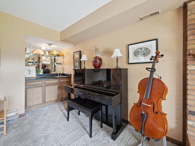 sitting room featuring indoor wet bar, baseboards, light colored carpet, and visible vents