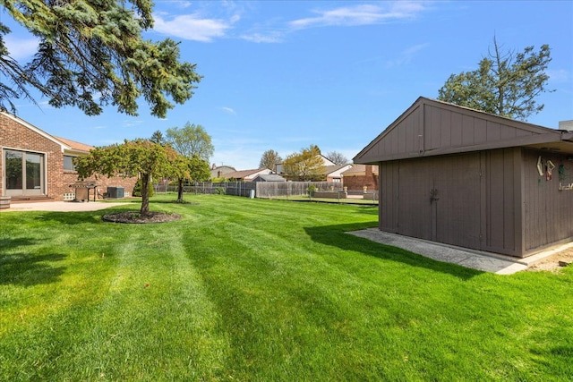view of yard featuring fence, an outbuilding, a shed, and a patio area