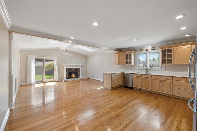 kitchen featuring appliances with stainless steel finishes, a sink, baseboards, ornamental molding, and glass insert cabinets