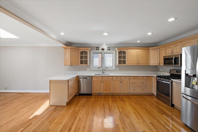 kitchen featuring ornamental molding, light brown cabinets, glass insert cabinets, a sink, and appliances with stainless steel finishes
