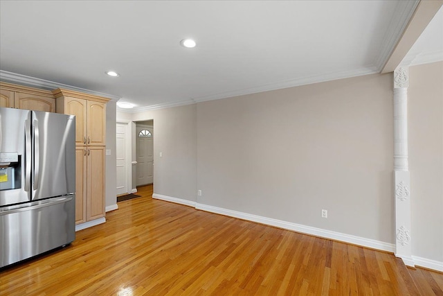 kitchen with crown molding, baseboards, stainless steel fridge, and light wood-style floors