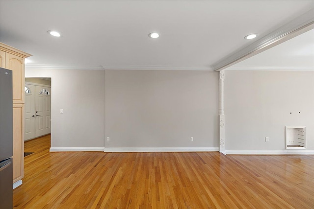spare room with baseboards, ornamental molding, and light wood-type flooring