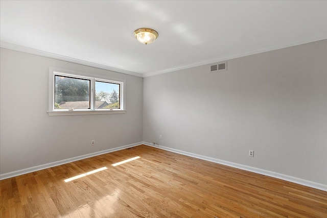 unfurnished room featuring crown molding, baseboards, visible vents, and light wood-type flooring