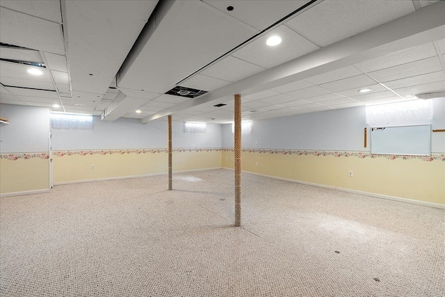 below grade area featuring carpet floors, recessed lighting, and a paneled ceiling