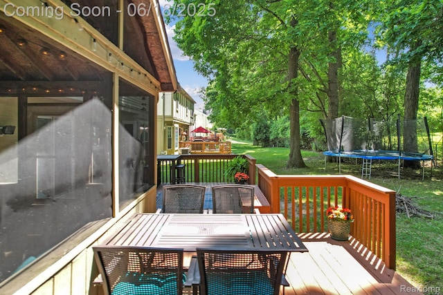1710 Dawncrest Dr, West Bloomfield, MI 48324 - wooden terrace featuring a trampoline, a yard, outdoor dining space, and a sunroom