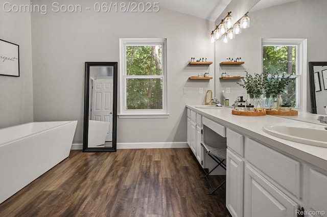 1710 Dawncrest Dr, West Bloomfield, MI 48324 - bathroom featuring double vanity, vaulted ceiling, wood finished floors, plenty of natural light, and a soaking tub