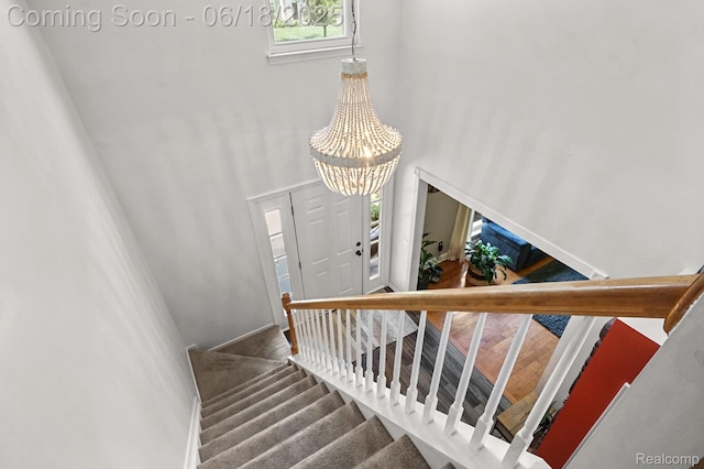 1710 Dawncrest Dr, West Bloomfield, MI 48324 - stairway with a towering ceiling, a chandelier, and carpet flooring