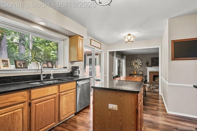 1710 Dawncrest Dr, West Bloomfield, MI 48324 - kitchen with stainless steel dishwasher, a center island, dark wood-type flooring, and a brick fireplace