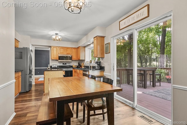 1710 Dawncrest Dr, West Bloomfield, MI 48324 - kitchen with appliances with stainless steel finishes, a chandelier, wood finished floors, and dark countertops