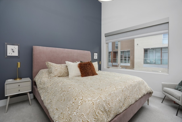 carpeted bedroom featuring baseboards and multiple windows