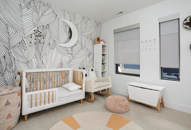 bedroom featuring visible vents, baseboards, carpet floors, and a nursery area