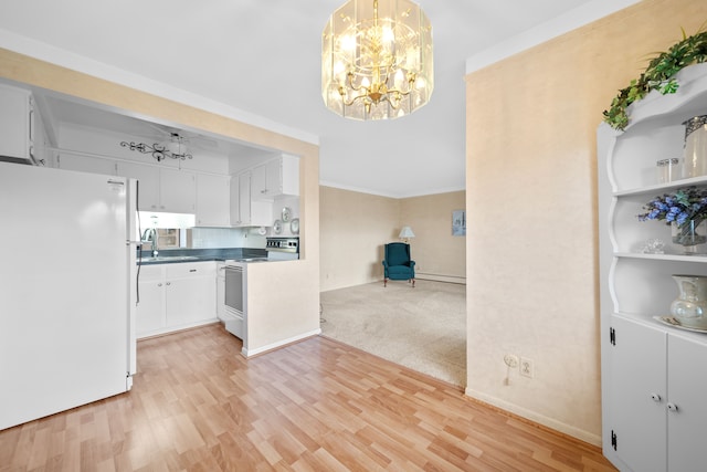 kitchen with dark countertops, light wood-type flooring, an inviting chandelier, white appliances, and white cabinetry