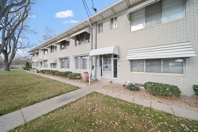 view of front of house with brick siding and a front lawn