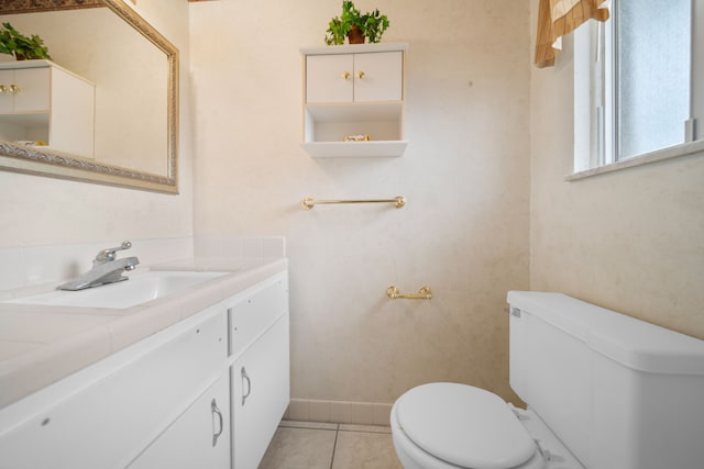 bathroom featuring vanity, baseboards, tile patterned flooring, and toilet