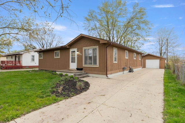 ranch-style house with an outdoor structure, fence, a front yard, driveway, and a detached garage