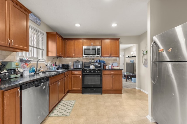 kitchen featuring brown cabinetry, a sink, and stainless steel appliances