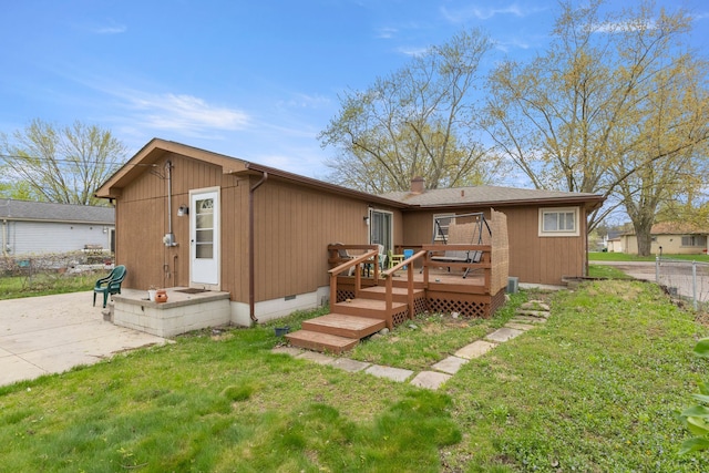 back of property featuring a lawn, crawl space, fence, and a deck