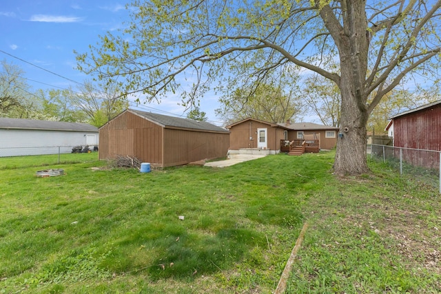 view of yard featuring an outdoor structure, a fenced backyard, and a patio area