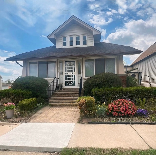 bungalow featuring entry steps and a shingled roof