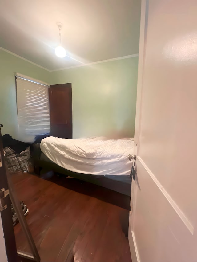 bedroom featuring crown molding and wood finished floors
