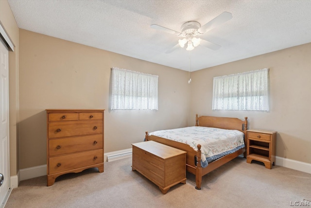 bedroom with light colored carpet, multiple windows, and a closet