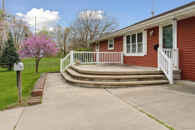 wooden deck featuring a lawn