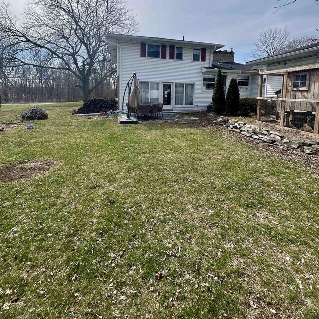 613 E Rolston, Linden, MI 48415 - rear view of house featuring a yard