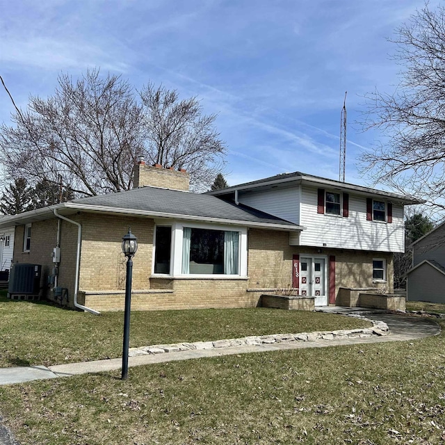 613 E Rolston, Linden, MI 48415 - tri-level home featuring brick siding, central AC, a chimney, and a front yard