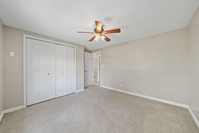 unfurnished bedroom with a ceiling fan, baseboards, carpet, and a closet