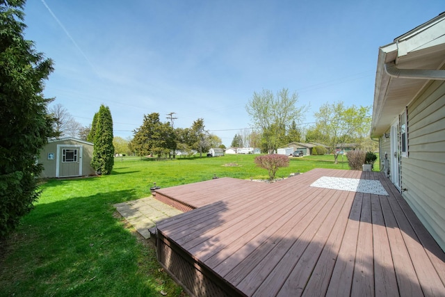 wooden terrace featuring a lawn and an outbuilding