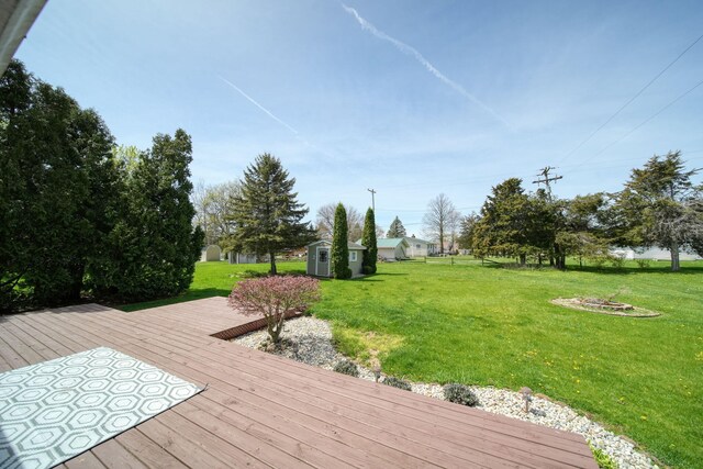 deck featuring a storage shed, an outdoor structure, and a yard