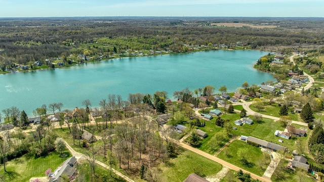 drone / aerial view featuring a water view, a residential view, and a wooded view
