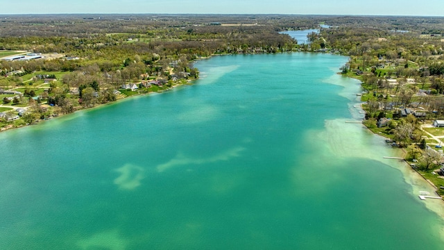 drone / aerial view featuring a water view and a wooded view