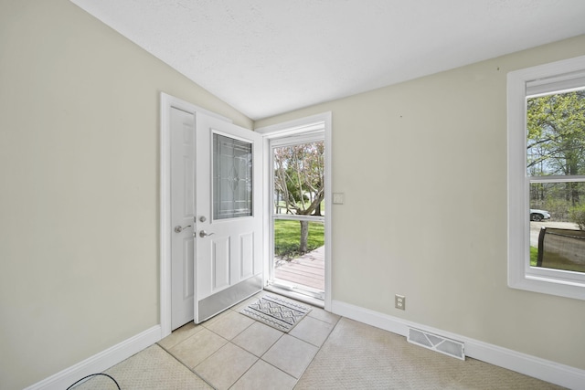 doorway to outside with baseboards, a wealth of natural light, and visible vents