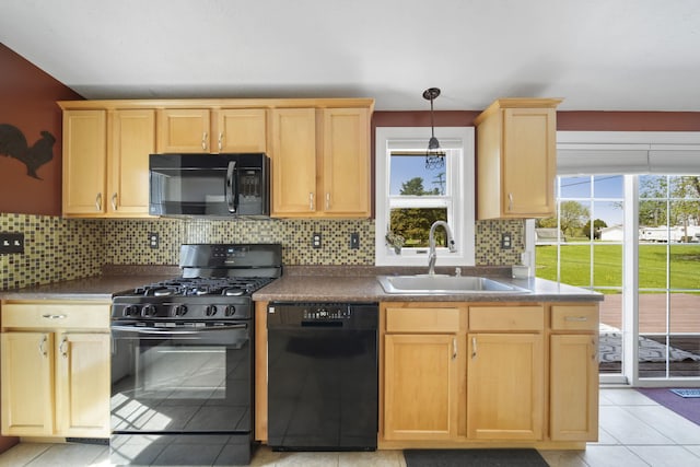 kitchen with dark countertops, a sink, black appliances, and light brown cabinets