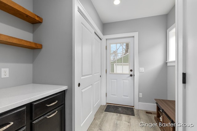 entryway featuring baseboards, recessed lighting, and light wood finished floors