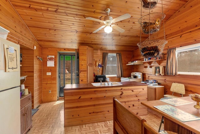 kitchen featuring a sink, vaulted ceiling, a healthy amount of sunlight, and white electric range