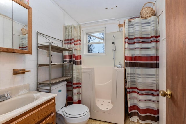 bathroom featuring toilet, tile walls, a shower with shower curtain, and vanity