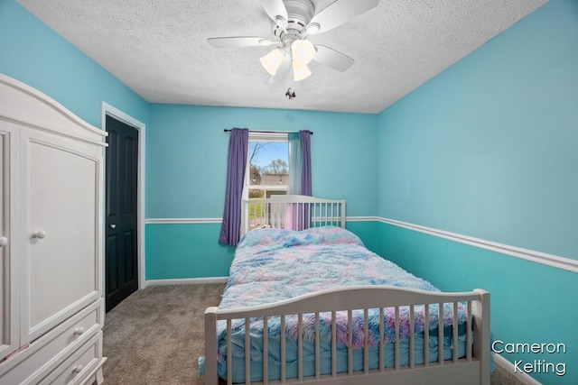bedroom featuring baseboards, carpet flooring, a textured ceiling, and a ceiling fan