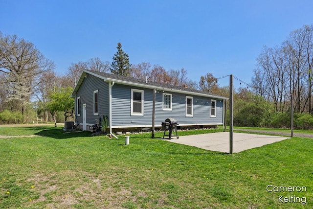 view of front of property with central air condition unit, a patio area, and a front yard