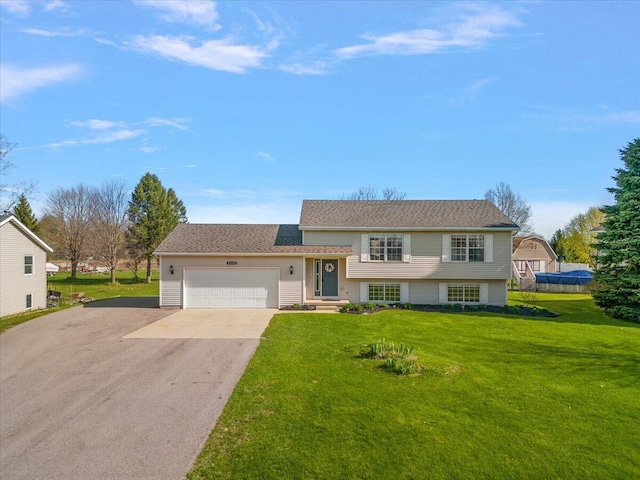 split level home featuring a garage, aphalt driveway, and a front yard