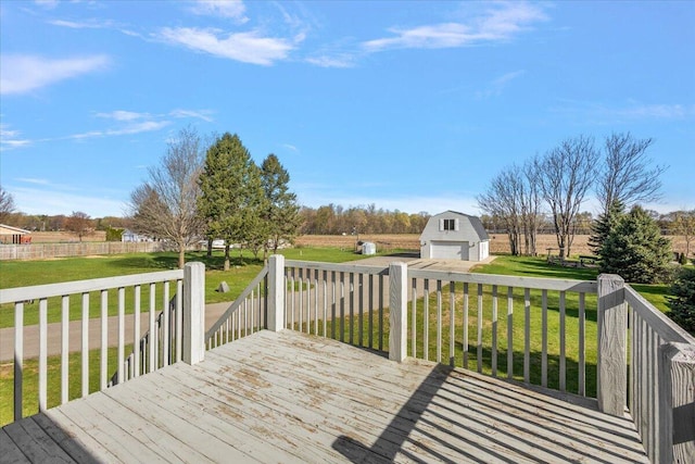 wooden deck featuring a lawn, a rural view, an outbuilding, and a garage