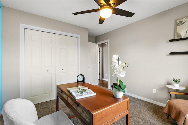 carpeted office space with baseboards and a ceiling fan